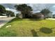View of home exterior showcasing the yard and fencing at 1801 Hibiscus S Ct, Oldsmar, FL 34677
