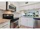 Bright kitchen featuring stainless steel appliances, white cabinetry, and marble countertops with a great view to the living area at 6218 Palma Del Mar S Blvd # 103, St Petersburg, FL 33715