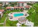 Aerial view of the community pool, complete with tiki huts, lounge chairs, and manicured landscaping at 6218 Palma Del Mar S Blvd # 103, St Petersburg, FL 33715