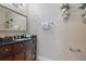 Stylish half bath featuring a wood vanity, granite countertop, and decorative shelves at 4239 Brentwood Park Cir, Tampa, FL 33624