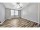 Neutral bedroom featuring wood-look flooring, a ceiling fan, and a window providing natural light at 4239 Brentwood Park Cir, Tampa, FL 33624