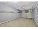 Spacious garage featuring a speckled epoxy floor, neutral gray walls, and overhead storage shelving at 4239 Brentwood Park Cir, Tampa, FL 33624