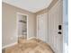 Hallway featuring neutral paint, a tile floor, and views to a powder room and closet at 4239 Brentwood Park Cir, Tampa, FL 33624
