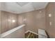 Upper-level landing with modern light fixture, linen closet, and continued wood-look flooring at 4239 Brentwood Park Cir, Tampa, FL 33624