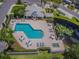 Aerial view of a community pool and amenity center with lounge chairs and lush landscaping at 4239 Brentwood Park Cir, Tampa, FL 33624