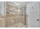 Glass-enclosed shower boasts stylish tile, shower caddy and modern fixtures at 4239 Brentwood Park Cir, Tampa, FL 33624