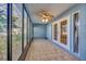 Inviting sunroom with tile flooring, large windows for natural light, and access doors to both the interior and exterior at 4239 Brentwood Park Cir, Tampa, FL 33624
