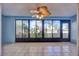 Enclosed sunroom featuring tile flooring, large windows offering serene views, and a unique ceiling fan at 4239 Brentwood Park Cir, Tampa, FL 33624