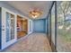 Bright sunroom boasts tile floors, a decorative ceiling fan, and seamless transition to the kitchen through French doors at 4239 Brentwood Park Cir, Tampa, FL 33624