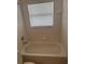 Bathroom with a tub and shower head under a window with closed blinds at 4706 Dragon Tail Ct, Valrico, FL 33594