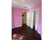 Bedroom with a pink wall, hardwood floors, an open closet and doorway to the kitchen at 4706 Dragon Tail Ct, Valrico, FL 33594
