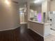 Open-concept living room with dark wood flooring leading to kitchen with white cabinets and breakfast bar at 4706 Dragon Tail Ct, Valrico, FL 33594