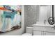 Modern bathroom with unique, stylish tile design, white vanity, and an artistic painting at 14448 Woodland Preserve Trl, Parrish, FL 34219