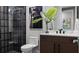 Bathroom with dark-tiled shower, modern vanity, unique artwork, and an accent mirror at 14448 Woodland Preserve Trl, Parrish, FL 34219