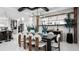 Modern dining room featuring a large wooden table, stylish chairs, and a view of the kitchen at 14448 Woodland Preserve Trl, Parrish, FL 34219