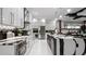Contemporary kitchen featuring glossy white cabinets, patterned backsplash, and stainless steel appliances at 14448 Woodland Preserve Trl, Parrish, FL 34219