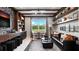 A cozy living area with built-in shelves, a sleek black sofa, and a view of the outdoors at 14448 Woodland Preserve Trl, Parrish, FL 34219