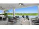 Cozy outdoor patio with comfortable seating, ceiling fans, and serene views of the lake at 14448 Woodland Preserve Trl, Parrish, FL 34219