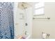 Bathroom featuring a shower-tub combo with a shower curtain and a window for natural light at 6310 Cecelia Dr, New Port Richey, FL 34653