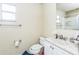 Modest bathroom featuring a white vanity, toilet, and a window providing natural light at 6310 Cecelia Dr, New Port Richey, FL 34653
