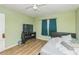 Bedroom with hardwood floors, a ceiling fan, and a TV on a black console at 6310 Cecelia Dr, New Port Richey, FL 34653