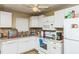 Bright kitchen featuring white cabinetry, essential appliances, and plenty of counter space for meal preparation at 6310 Cecelia Dr, New Port Richey, FL 34653