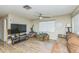 Comfortable living room featuring wood-look floors, a ceiling fan, and natural light at 6310 Cecelia Dr, New Port Richey, FL 34653