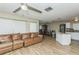 Open-concept living area with wood floors, ceiling fan, and plenty of natural light at 6310 Cecelia Dr, New Port Richey, FL 34653
