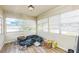 Sunroom with wood laminate flooring, windows, and clutter at 6310 Cecelia Dr, New Port Richey, FL 34653