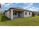 Rear exterior with a covered patio area and grassy backyard under a bright blue sky at 13209 Haystack Ct, Riverview, FL 33579