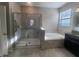 Luxurious bathroom with a glass-enclosed shower, soaking tub, and granite vanity at 13209 Haystack Ct, Riverview, FL 33579