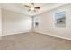 Light-filled main bedroom with neutral carpet, a ceiling fan, and two windows at 13209 Haystack Ct, Riverview, FL 33579