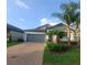 Charming single-story home with a gray exterior, brick driveway, and well-maintained landscaping at 13209 Haystack Ct, Riverview, FL 33579