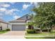 Charming single-story home with a brick driveway, gray garage door and well-manicured landscaping in the front yard at 13209 Haystack Ct, Riverview, FL 33579