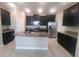 Modern kitchen features dark cabinets, stainless steel appliances, granite countertops, and a center island at 13209 Haystack Ct, Riverview, FL 33579