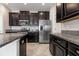 Modern kitchen featuring stainless steel appliances, dark cabinets, granite countertops and tile floors at 13209 Haystack Ct, Riverview, FL 33579