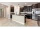 Modern kitchen featuring stainless steel appliances, dark cabinets, granite countertops and a kitchen island with a sink at 13209 Haystack Ct, Riverview, FL 33579