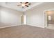 Spacious primary bedroom with tray ceiling, carpet, and ensuite bathroom access at 13209 Haystack Ct, Riverview, FL 33579