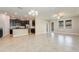 Open concept living area with tile floors, view of the kitchen with dark cabinets and stainless steel appliances at 13209 Haystack Ct, Riverview, FL 33579