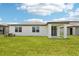 The house has a well-maintained backyard with green grass, windows, and a covered patio at 1732 Brekey Way, Zephyrhills, FL 33541