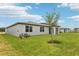 The house has a well-maintained backyard with green grass, windows, and a covered patio at 1732 Brekey Way, Zephyrhills, FL 33541