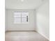 Bright bedroom with neutral walls and tile floor, illuminated by a window at 1732 Brekey Way, Zephyrhills, FL 33541