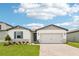 Charming one-story home showcasing a beautiful lawn, brick driveway, and a two-car garage at 1732 Brekey Way, Zephyrhills, FL 33541