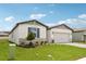 Charming one-story home featuring stone accents, a two-car garage, and a well-manicured front lawn at 1732 Brekey Way, Zephyrhills, FL 33541