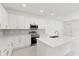 Bright, modern kitchen with white cabinets, quartz countertops, stainless steel appliances, and tile backsplash at 17330 Alderwood Ln, Punta Gorda, FL 33982