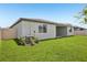 Exterior of the home from the yard featuring a covered patio and a well-maintained lawn at 1775 Draughton Dr, Zephyrhills, FL 33541