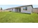 A spacious backyard with green grass and a covered patio for outdoor relaxation at 1775 Draughton Dr, Zephyrhills, FL 33541
