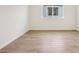 An empty bedroom with hard wood-style floors and a window with natural light at 1775 Draughton Dr, Zephyrhills, FL 33541