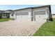 Spacious two-car garage with a beautiful paved driveway and manicured landscaping at 1775 Draughton Dr, Zephyrhills, FL 33541