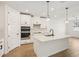 Modern kitchen with center island, white cabinets, black hardware, and stainless appliances at 1775 Draughton Dr, Zephyrhills, FL 33541